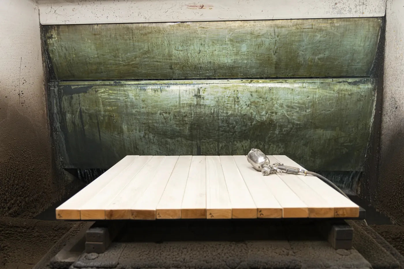 Panel resting in the finishing booth with a spray gun