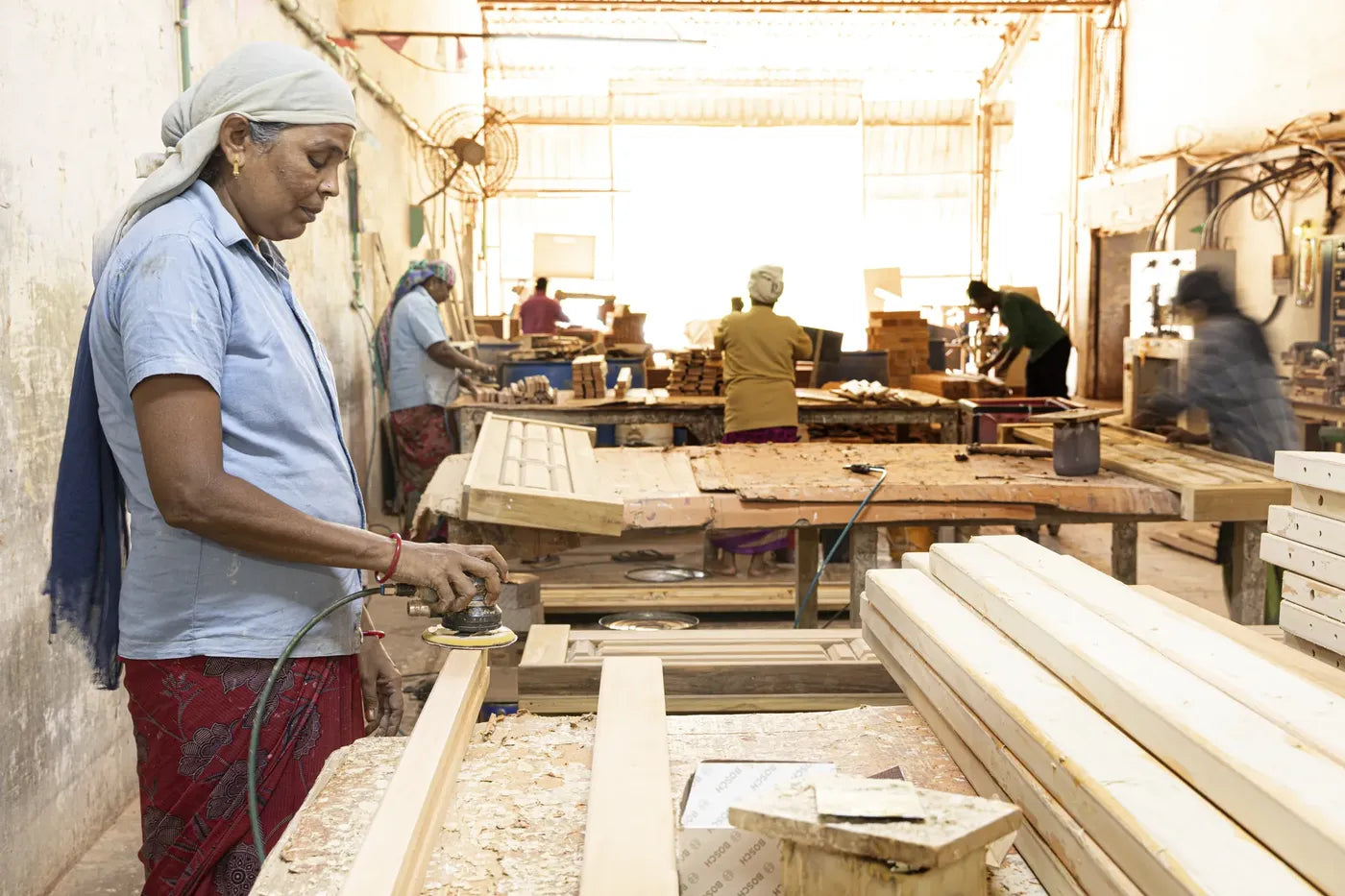 Craftswoman hand-sanding a timber frame