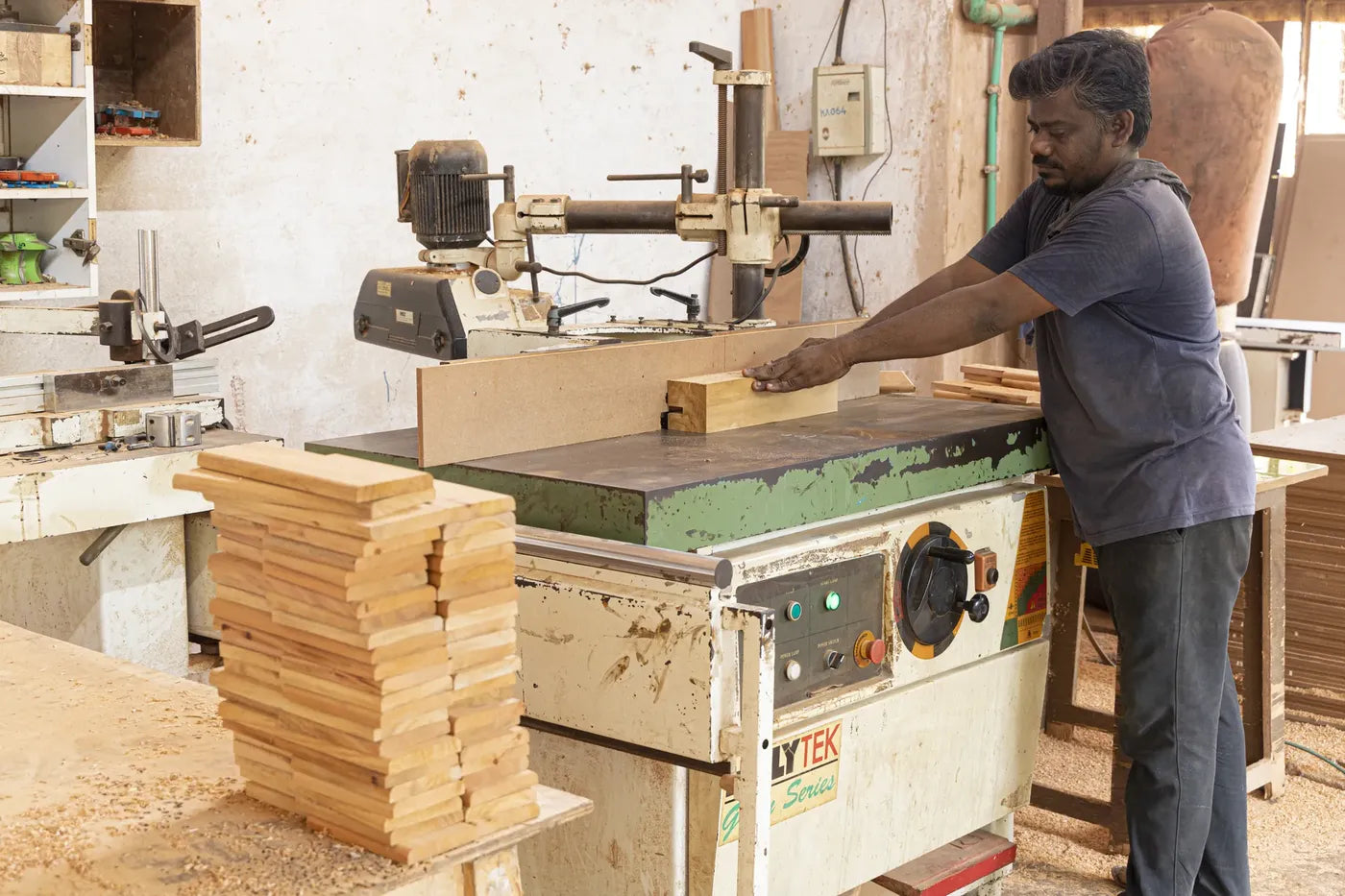 Craftsman shaping timber blocks on a spindle moulder